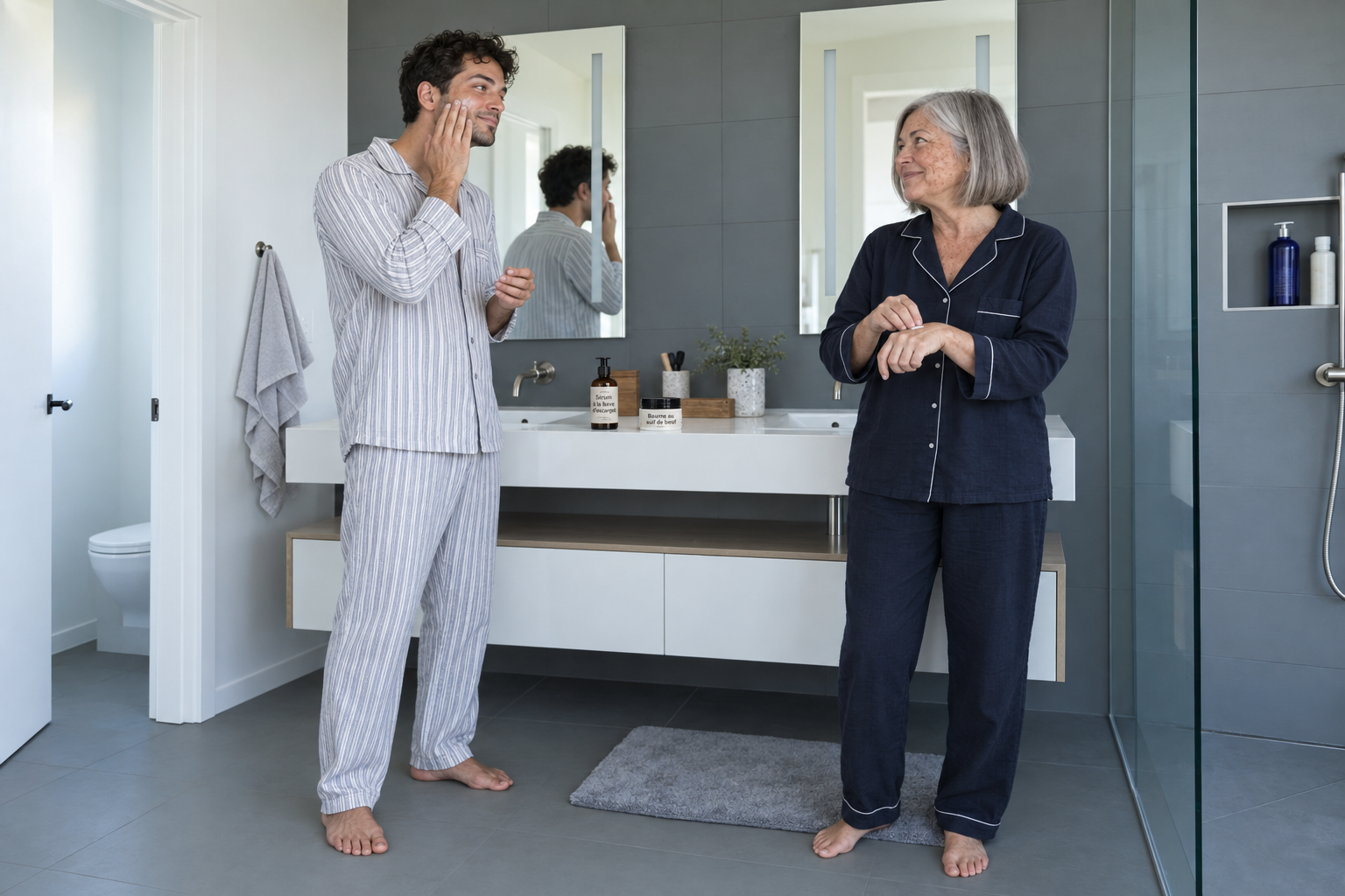 Jeune homme et femme âgée en pyjama appliquant un soin dans une salle de bains